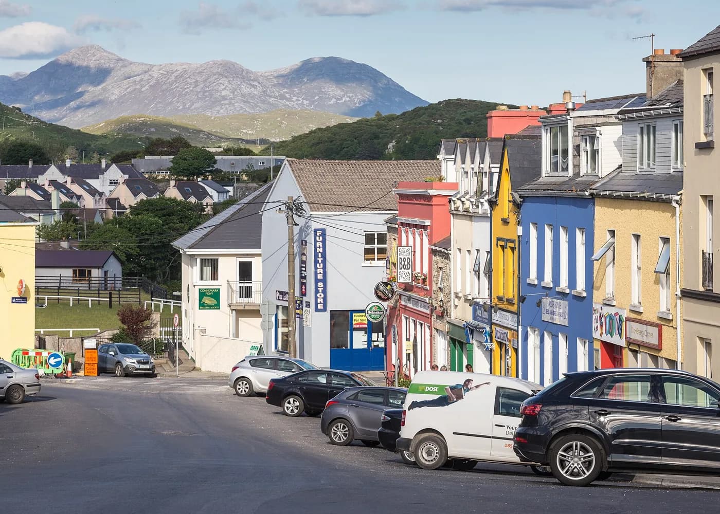 Clifden's main street sloping toward the harbour with the Twelve Bens of Connemara rising behind