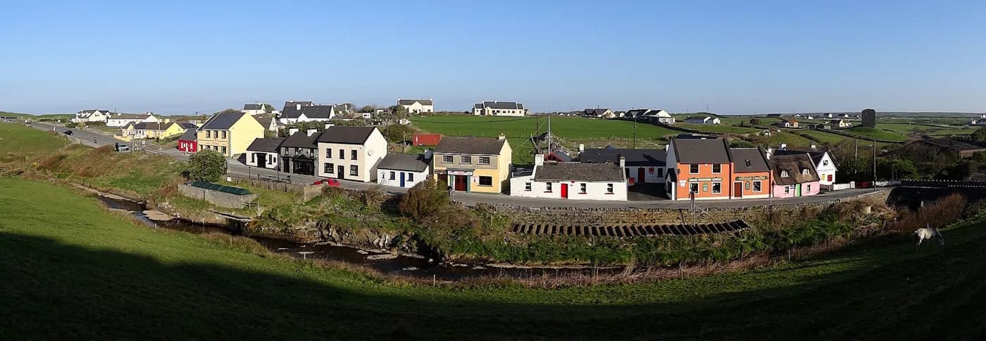 The coloured houses of Fisher Street in Doolin village with the Burren hills behind