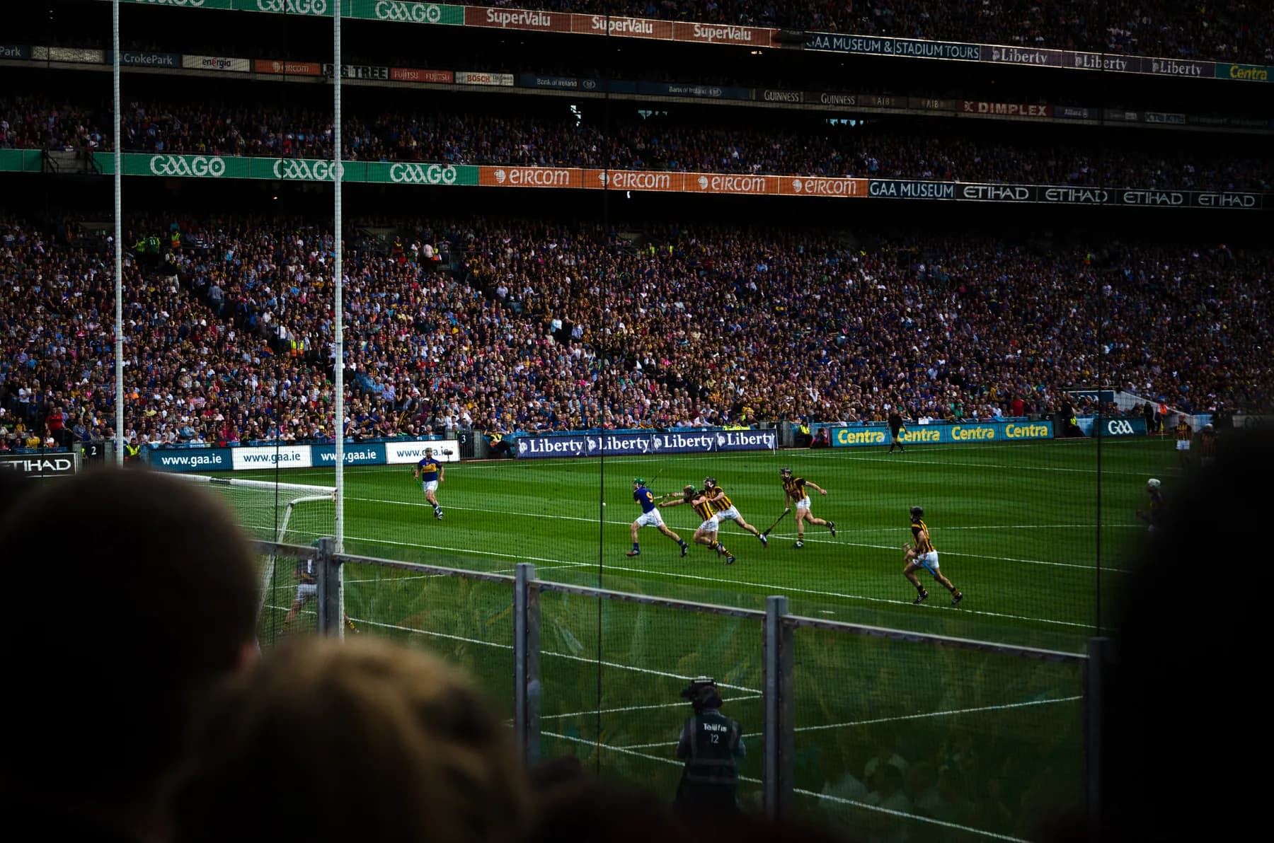 A hurling match in front of a packed Croke Park, players in Kilkenny and Tipperary county colours contesting the ball